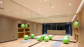 Un gimnasio moderno con pelotas de ejercicio, colchonetas de yoga y estanterías de madera.