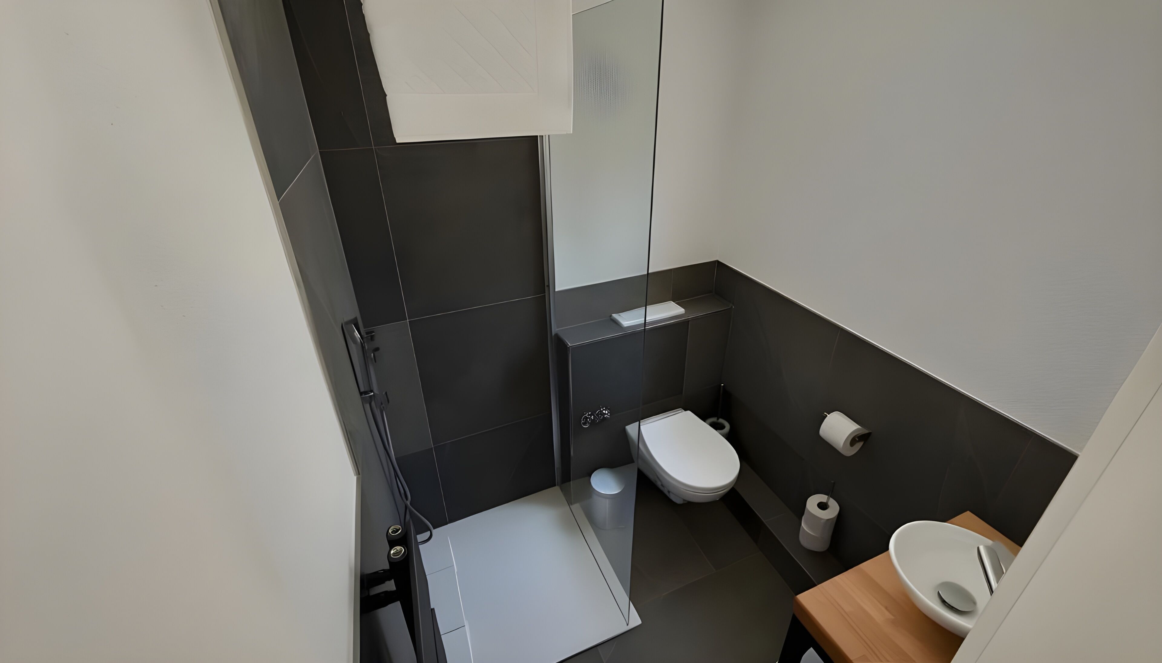 Un baño moderno con inodoro, bidé y una pequeña zona de lavamanos.