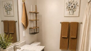 Un baño con lavamanos, inodoro y toallero.