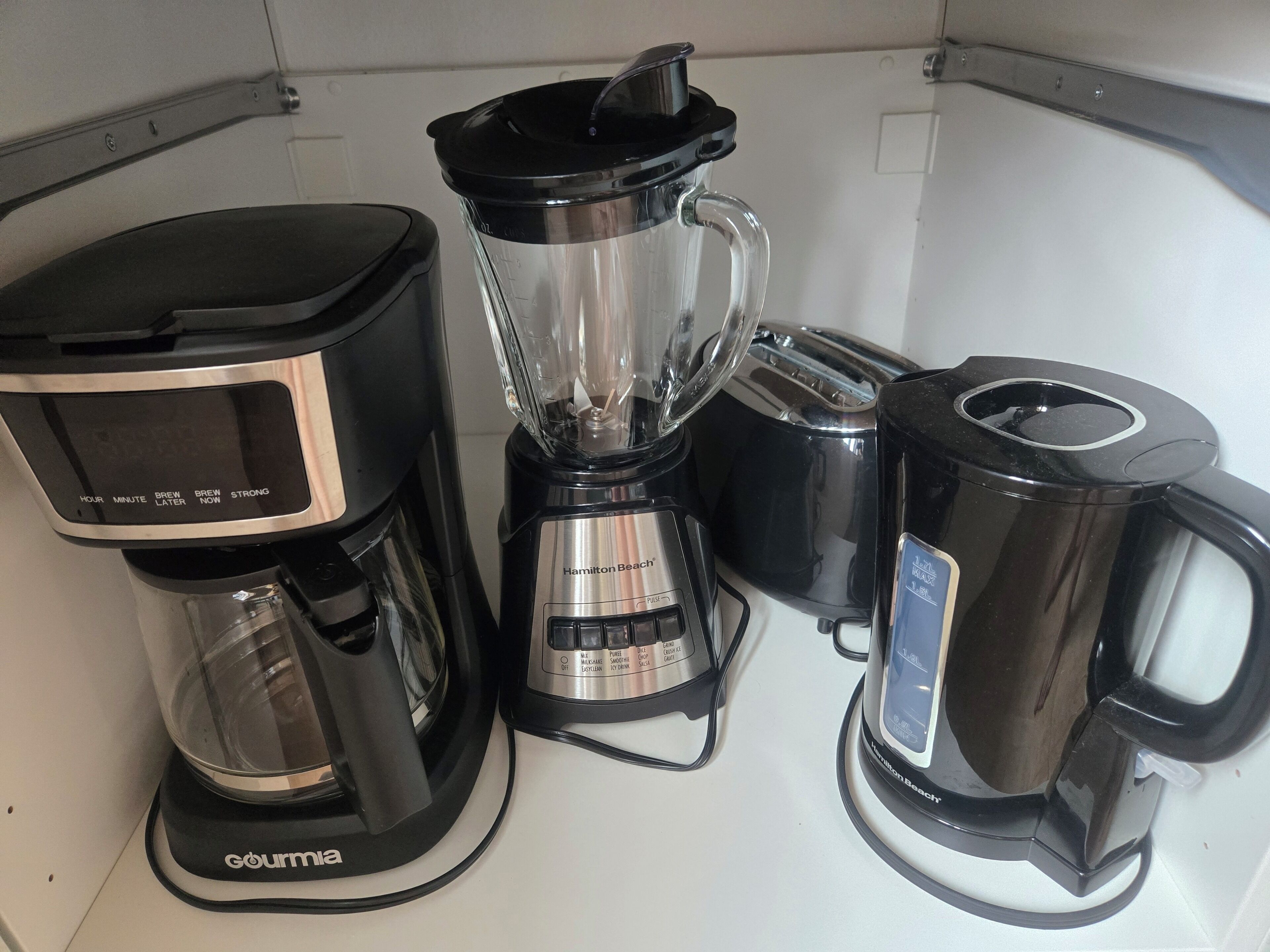 Cozinha com cafeteira, liquidificador e jarra de café.
