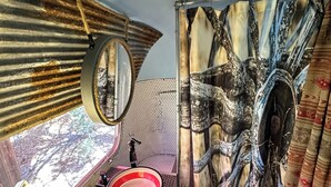 Une salle de bain équipée d’un meuble-lavabo, d’un miroir, d’un évier et de rideaux décoratifs.