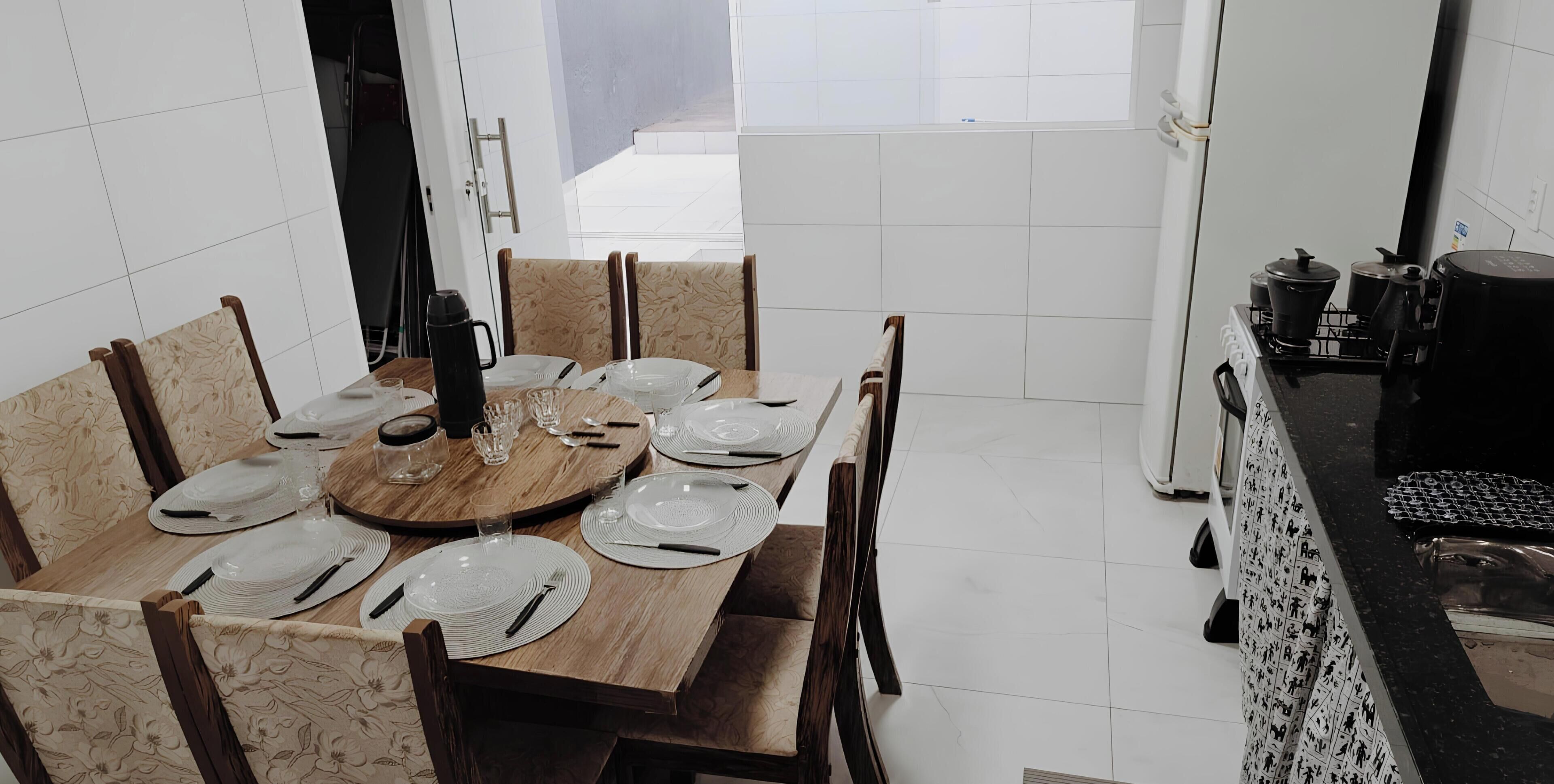 A dining area with a round table set for six, surrounded by chairs.. Comfort and Style | 7 Min Walk from Parque do Povo.
