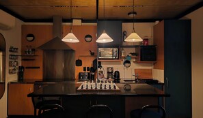 Una cucina con isola centrale, un forno a microonde, una macchina da caffè e un lavello.