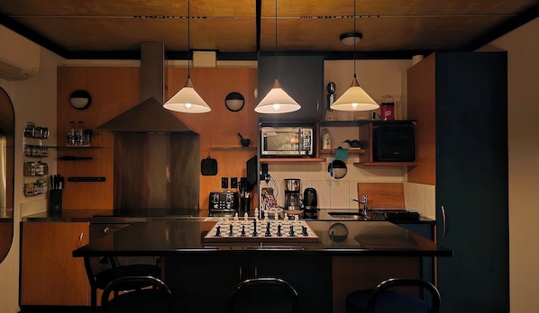 Eine Küche mit einer zentralen Kochinsel, einer Mikrowelle, einer Kaffeemaschine und einem Spülbecken.