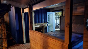 Una cabaña de madera con una cama litera, una mesita y vistas al exterior.
