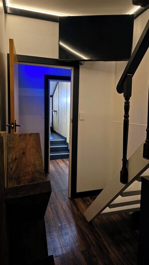 A staircase with a wooden handrail and a black accent wall. - Private Wellington Retreat centrally located, jacuzzi, bbq, theatre & much more! (Wellington)