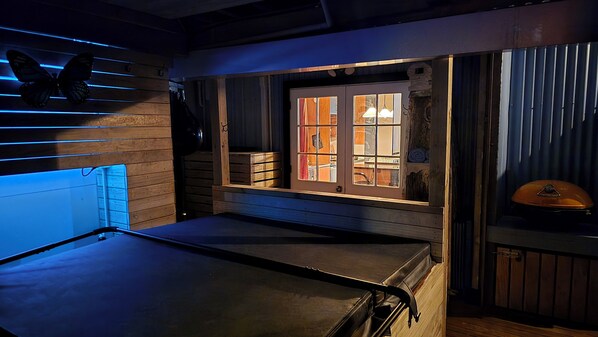 Una habitación con cama, ventana con cortinas, pared de madera y una decoración con mariposas.