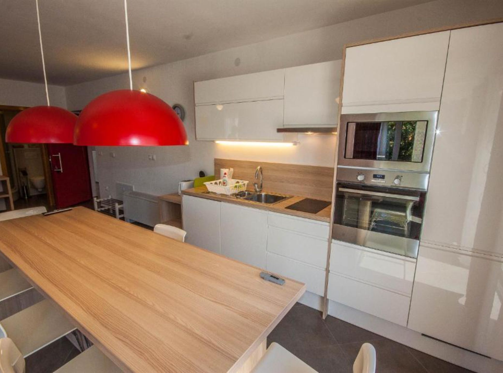 Una cocina moderna con armarios blancos, electrodomésticos de acero inoxidable y una isla de madera.