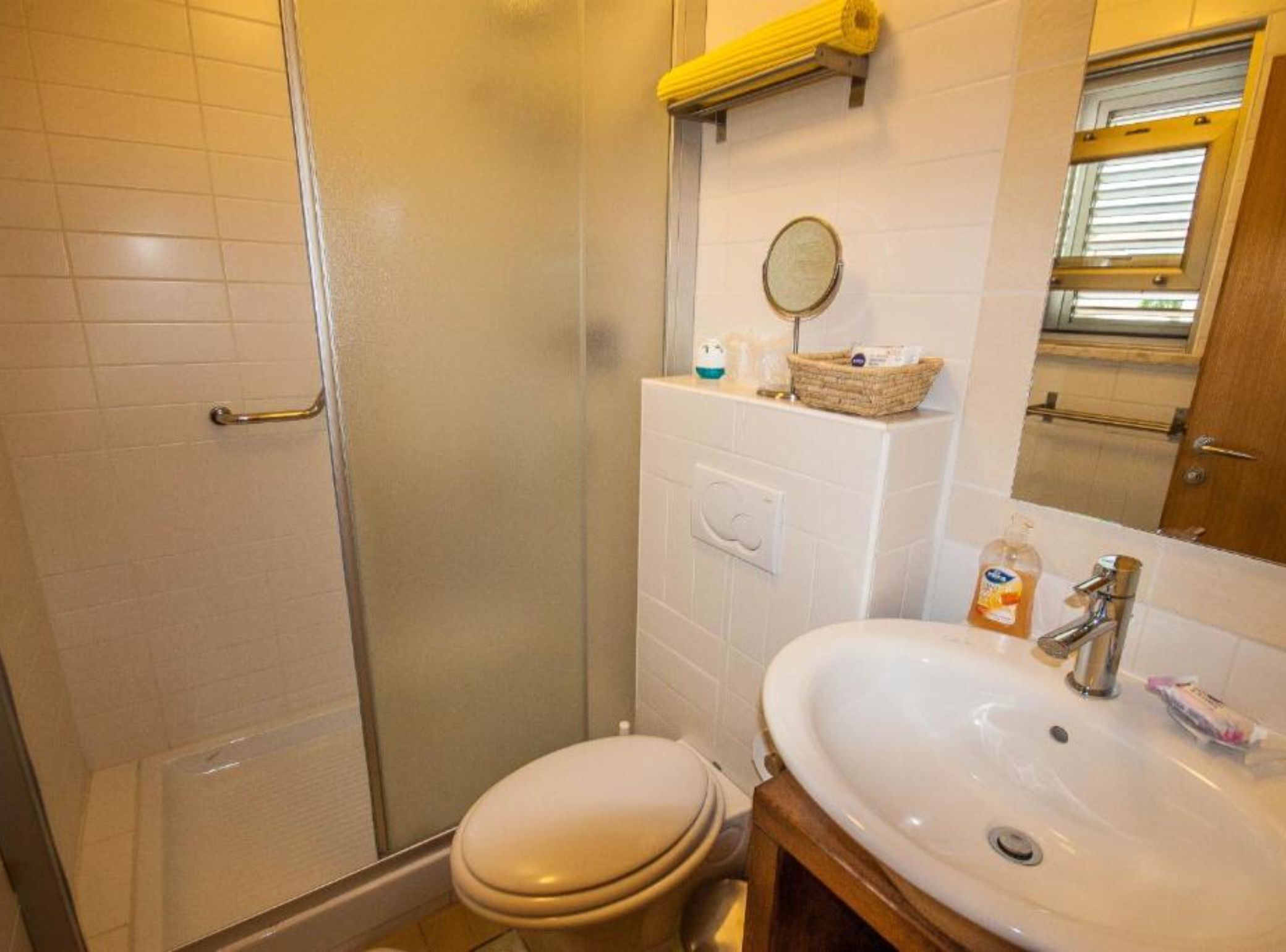 A bathroom with a toilet, sink, and shower.