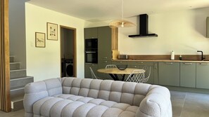 Eine moderne Küche mit Essbereich, einer Couch und einer Treppe.