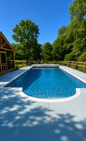 A rectangular swimming pool with a wooden deck and a covered seating area on one side. - Litchfield Hills Modern Design Escape w/ a Pool (Sharon)