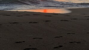 Ein Sonnenuntergang über dem Meer mit sich nähernden Wellen.