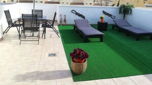 A rooftop terrace with a dining table, chairs, a sun lounger, a small table with a potted plant, and artificial grass. - ☀️🏖️ A DREAM VACATION AT PLAYA EL CARABASSÍ (ALICANTE)☀️🏖️ (Gran Alacant)