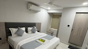 Un dormitorio moderno con cama, mesita de noche, espejo y puerta.