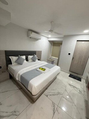 Ein modernes Schlafzimmer mit Bett, Nachttisch, Spiegel und Tür.