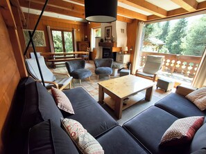 A cozy living area with a sofa set, a coffee table, and a fireplace. - Our family chalet in the heart of the Alps (Chamonix-Mont-Blanc)