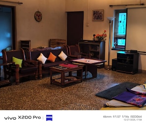 Una sala de estar con sofá, sillas, una mesa de centro, chimenea, televisor y ventana con vistas.