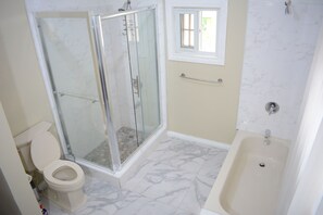 Un baño con ducha, inodoro y bañera.