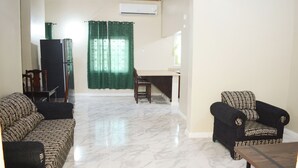 Una sala de estar con sofá, sillón y una pequeña mesa.