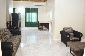 Una sala de estar con sofá, sillón y una pequeña mesa.