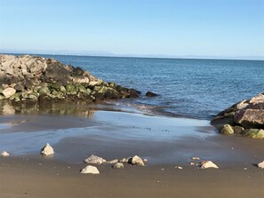 Une plage avec des rochers et une eau calme.