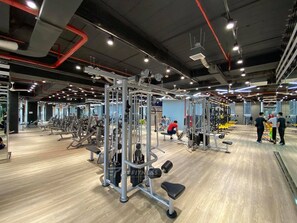 A gym with various exercise equipment, mirrors, and a wooden floor. - Nice Luxury Apartments The Sun Avenue (Ho Chi Minh City)