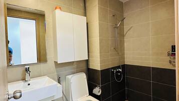 Ein Badezimmer mit Waschbecken, Toilette und Dusche.