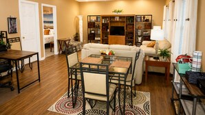 A living room with a dining area, a ceiling fan, a bookshelf, and a television. -  FIFA World Cup Atlanta Stay Sleeps 4 Pool 11 Min to Mercedes-Benz Stadium (Atlanta)