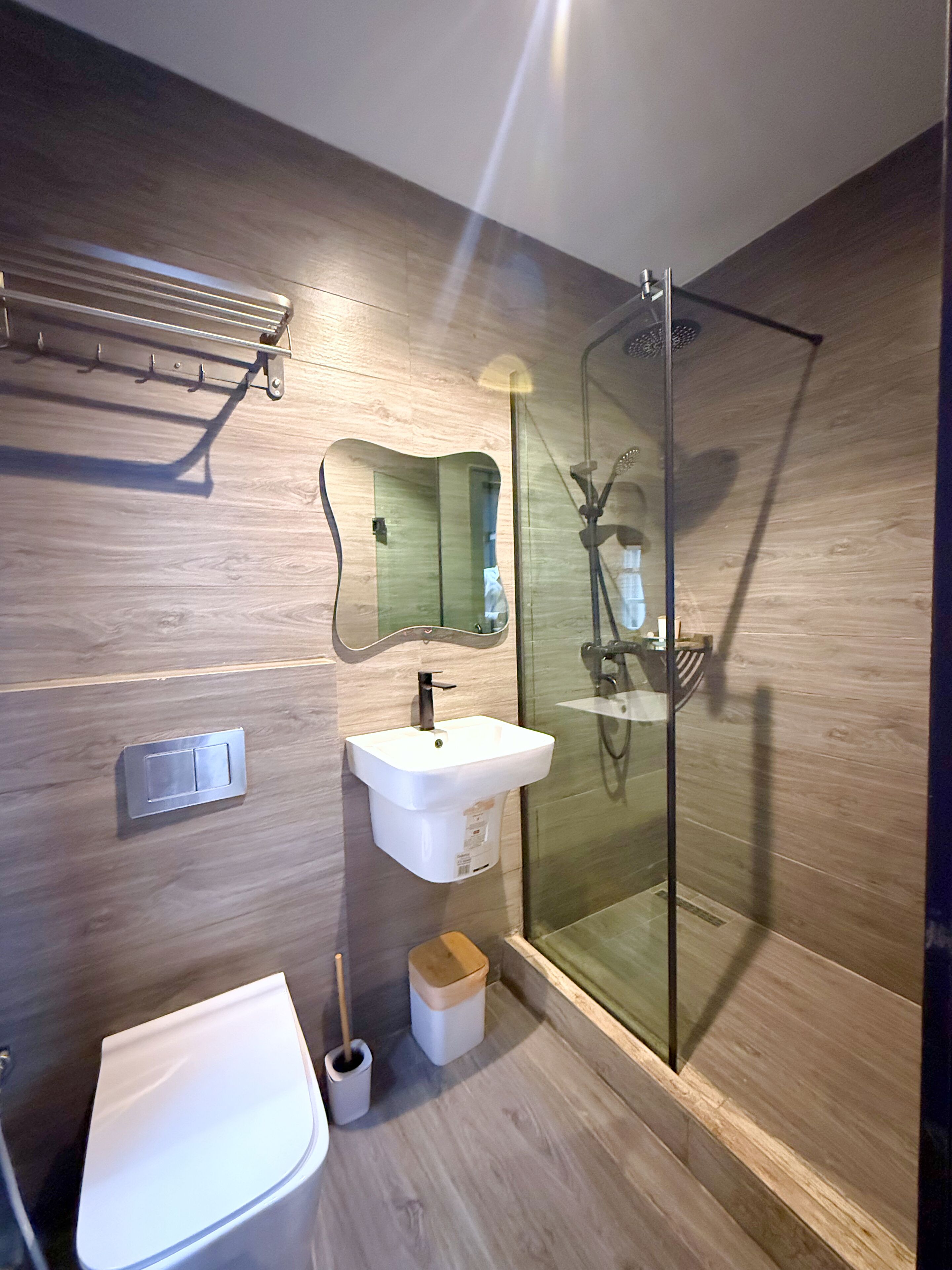 Une salle de bain moderne avec une douche à parois de verre, un lavabo blanc et des toilettes.
