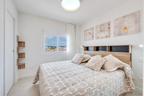 A bedroom with a bed, a window, and artwork on the wall. - LXR Nice 3-Bedroom Apartment Right on the Waterfront (Fuengirola)