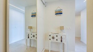 A modern bathroom with a white vanity, a mirror, and decorative wall signs. - LXR Nice 3-Bedroom Oceanfront (Fuengirola)