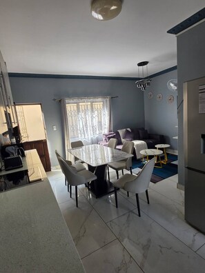 Un espacio habitable moderno con comedor, sofá y cocina.