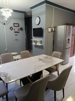 Una cocina moderna con una mesa de mármol, electrodomésticos integrados y un reloj en la pared.