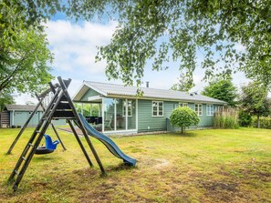 A house with a slide, a covered patio, and a small garden. - 6 Person Holiday Home in Hadsund (Hadsund)