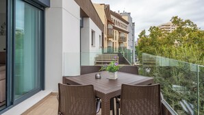 A balcony with a table and chairs, a glass railing, and a view of surrounding buildings. - LXR Meninas 2-Bedroom Apartment Near the Sea (Fuengirola)