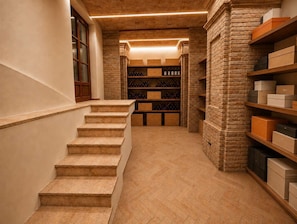 A staircase leading to a wine cellar with wooden steps and brick walls.
