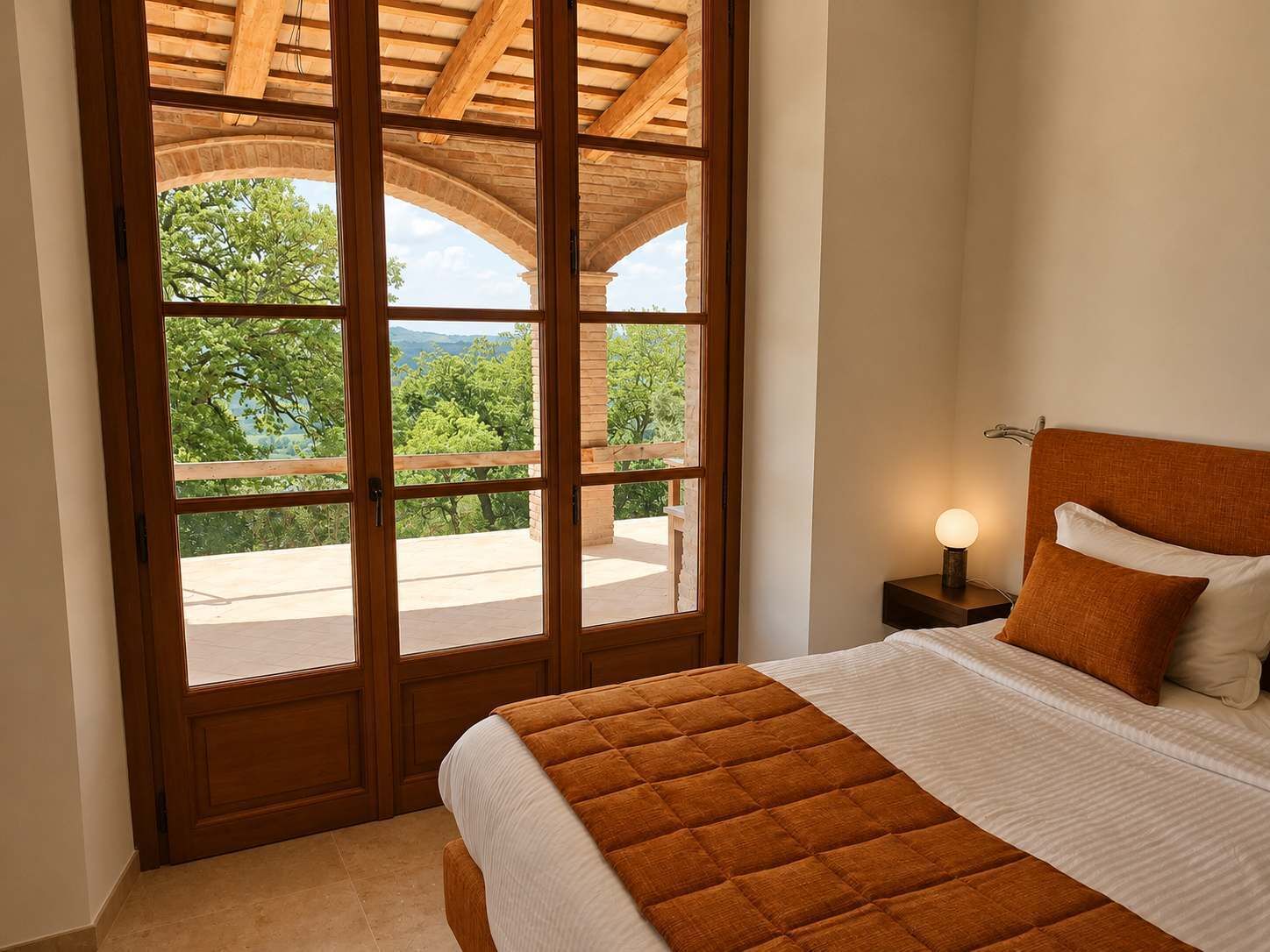 Una camera da letto con un letto, un comodino e vista su una zona esterna tramite una porta vetrata.