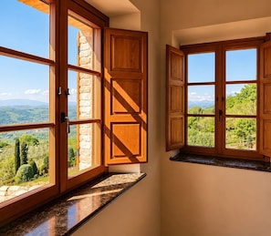 A kitchen with wooden cabinets and a view of a green landscape.