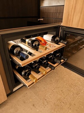 A wine rack with bottles in a kitchen setting. - Villa Santa Maria dell'Olmo (MORESCO)