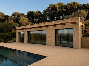A modern house with a pool, large windows, and a stone wall. - Villa Santa Maria dell'Olmo (MORESCO)