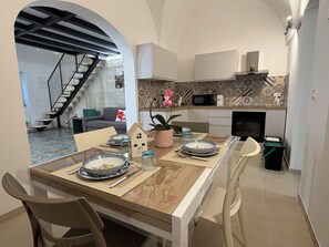 Una cocina moderna con comedor, una escalera y una sala de estar.