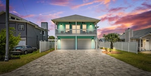 A two-story house with a balcony, a garage, and a driveway. - Raven's Nest - Mins to Beach Heated Pool & Pet Friendly (Panama City Beach)