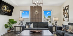 Una sala de estar con sofá, mesa de centro y lámparas decorativas.