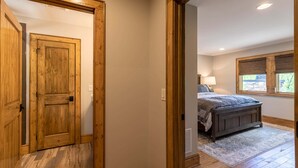 A bedroom with a bed, a window, and a door. - Howling at the Moon at Eagles Nest (Banner Elk)