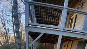 Una vasca idromassaggio con struttura in metallo, un pontile in legno e un edificio sullo sfondo.