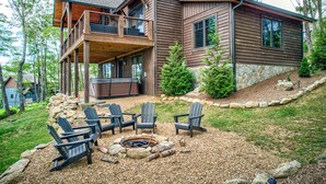 A two-story house with a covered deck, outdoor seating, and a fire pit. - Grayling Lodge at Eagles Nest (Banner Elk)