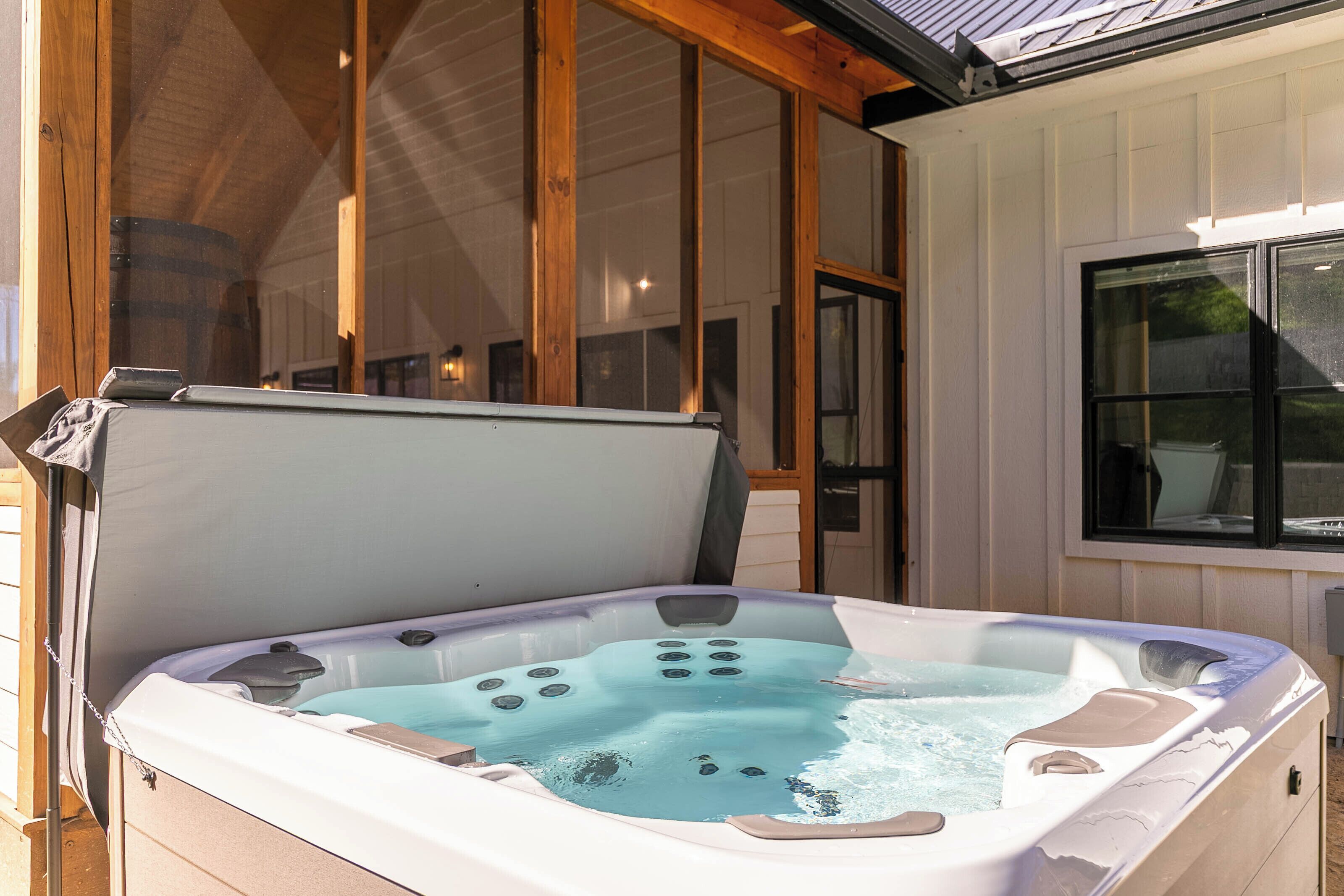 Een hottub met een deksel, houten balken en een raam.
