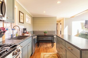 A kitchen with a stove, sink, and a bench. - Mountain View Retreat (Banner Elk)