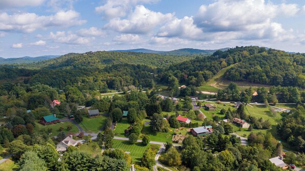 An aerial view of a rural area with scattered houses, green fields, and dense forests. - Horse Valley Lodge (Boone)