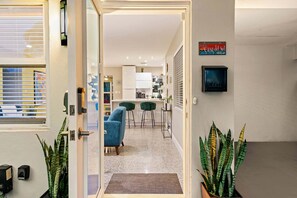 Ein modernes Interieur mit einer Küche, einem Essbereich und einem Flur zu einer Tür.